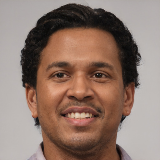 Joyful latino young-adult male with short  brown hair and brown eyes