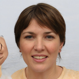 Joyful white young-adult female with medium  brown hair and brown eyes