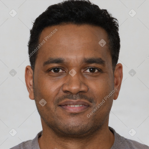 Joyful black young-adult male with short  brown hair and brown eyes