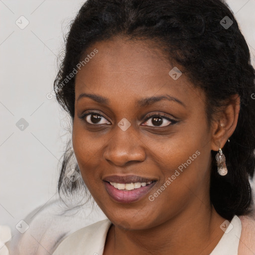 Joyful black young-adult female with long  brown hair and brown eyes