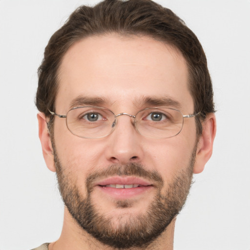 Joyful white adult male with short  brown hair and grey eyes