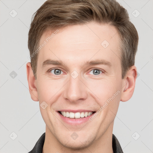 Joyful white young-adult male with short  brown hair and grey eyes