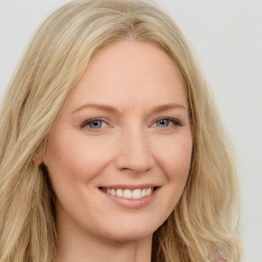 Joyful white young-adult female with long  blond hair and blue eyes