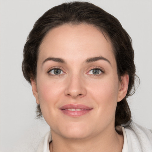 Joyful white young-adult female with medium  brown hair and grey eyes