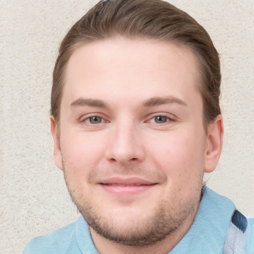 Joyful white young-adult male with short  brown hair and blue eyes