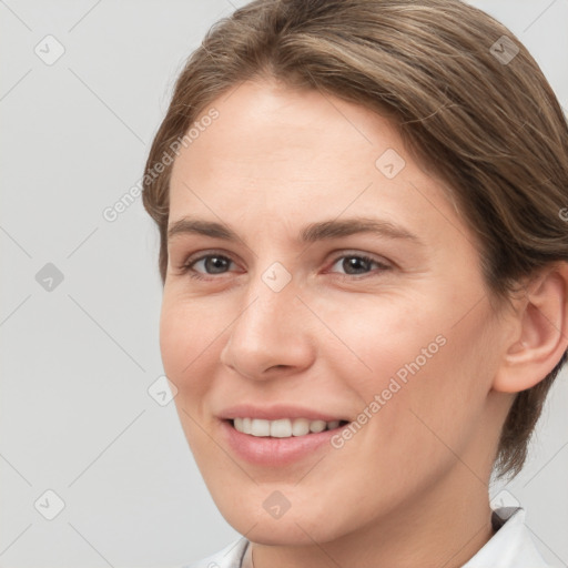 Joyful white young-adult female with short  brown hair and grey eyes