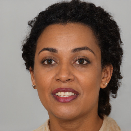 Joyful black young-adult female with short  brown hair and brown eyes