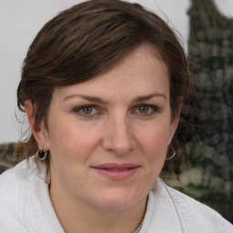 Joyful white young-adult female with medium  brown hair and grey eyes