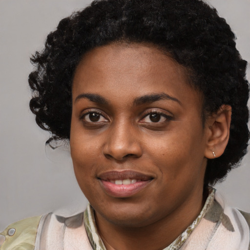 Joyful black young-adult female with short  black hair and brown eyes