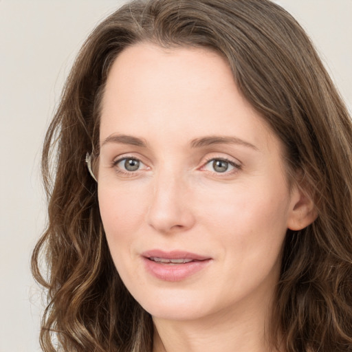 Joyful white young-adult female with long  brown hair and green eyes