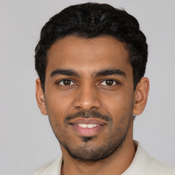 Joyful latino young-adult male with short  black hair and brown eyes