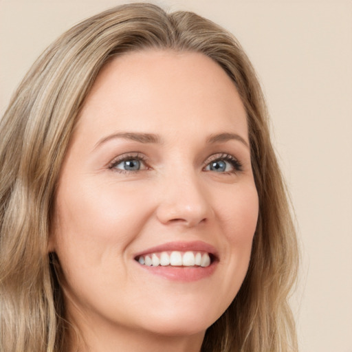 Joyful white young-adult female with long  brown hair and green eyes