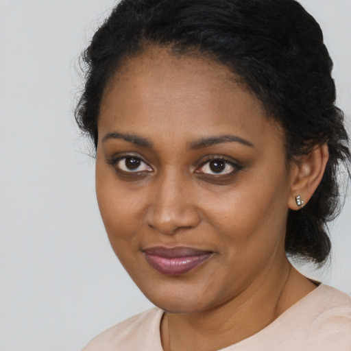 Joyful black young-adult female with short  brown hair and brown eyes