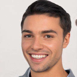 Joyful white young-adult male with short  black hair and brown eyes