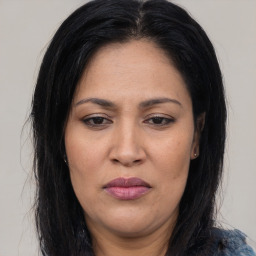 Joyful latino adult female with long  brown hair and brown eyes