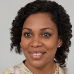 Joyful black adult female with medium  brown hair and brown eyes