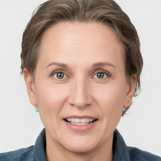 Joyful white adult female with medium  brown hair and grey eyes