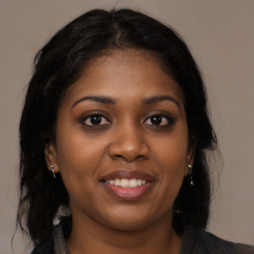 Joyful black young-adult female with long  brown hair and brown eyes