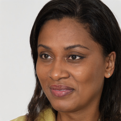 Joyful black young-adult female with long  brown hair and brown eyes