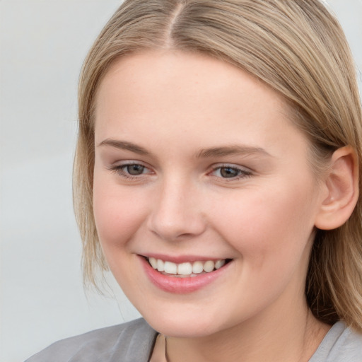 Joyful white young-adult female with medium  brown hair and blue eyes