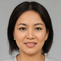 Joyful latino young-adult female with medium  brown hair and brown eyes