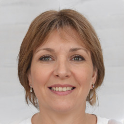 Joyful white adult female with medium  brown hair and grey eyes