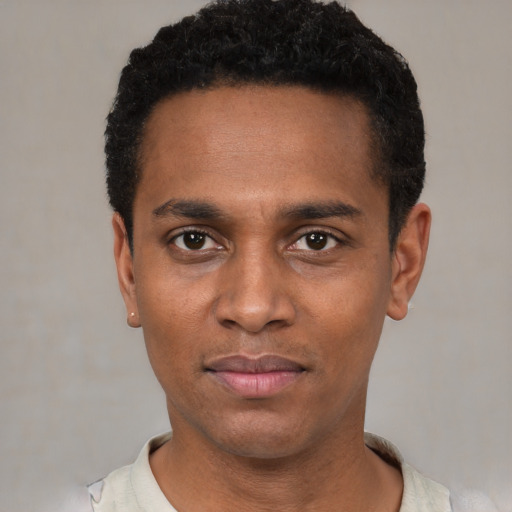 Joyful black young-adult male with short  black hair and brown eyes