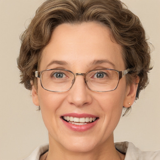 Joyful white adult female with medium  brown hair and green eyes