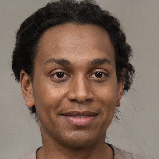 Joyful black adult female with short  brown hair and brown eyes