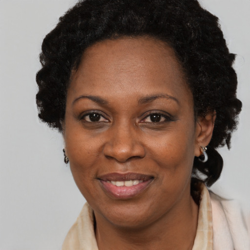 Joyful black adult female with long  brown hair and brown eyes