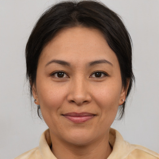 Joyful asian adult female with medium  brown hair and brown eyes