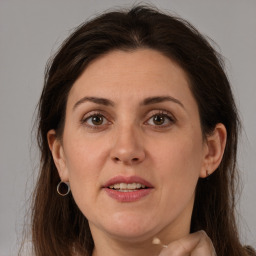 Joyful white adult female with long  brown hair and grey eyes