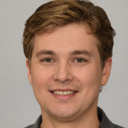 Joyful white adult male with short  brown hair and grey eyes