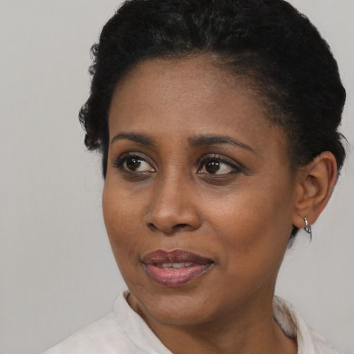 Joyful black adult female with short  black hair and brown eyes