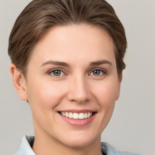 Joyful white young-adult female with short  brown hair and grey eyes