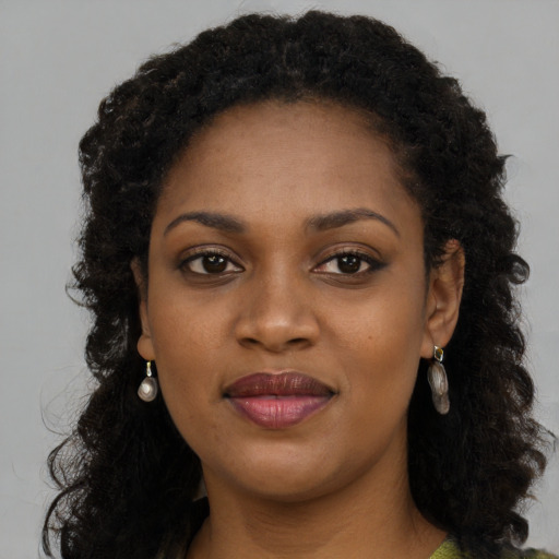 Joyful black young-adult female with long  brown hair and brown eyes
