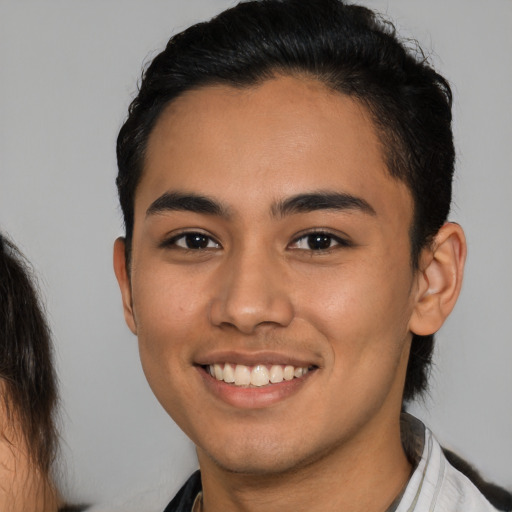 Joyful latino young-adult male with medium  brown hair and brown eyes