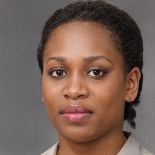 Joyful black young-adult female with short  brown hair and brown eyes