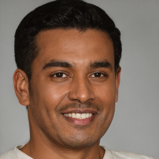 Joyful latino young-adult male with short  brown hair and brown eyes