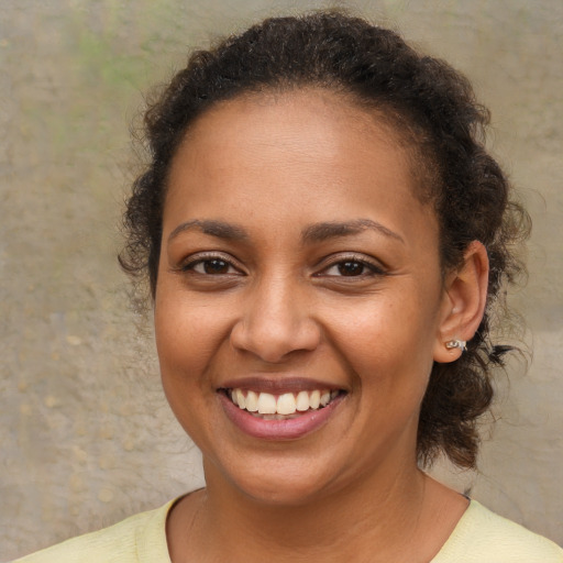 Joyful black young-adult female with medium  brown hair and brown eyes