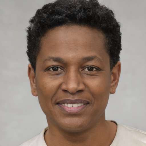 Joyful black young-adult male with short  brown hair and brown eyes
