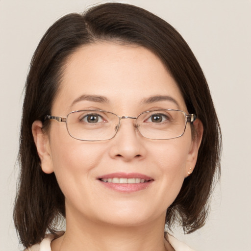 Joyful white adult female with medium  brown hair and grey eyes