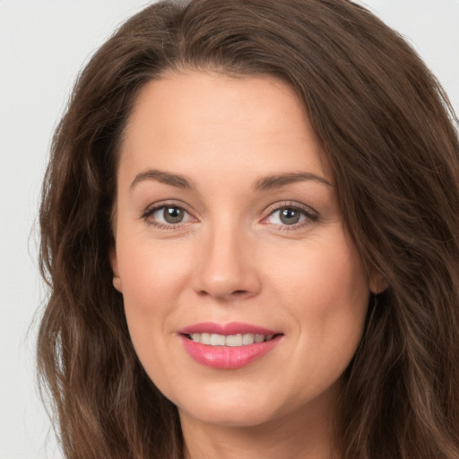 Joyful white young-adult female with long  brown hair and green eyes