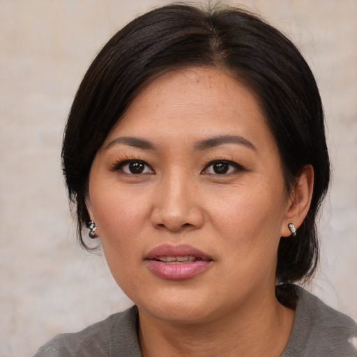 Joyful asian adult female with medium  black hair and brown eyes