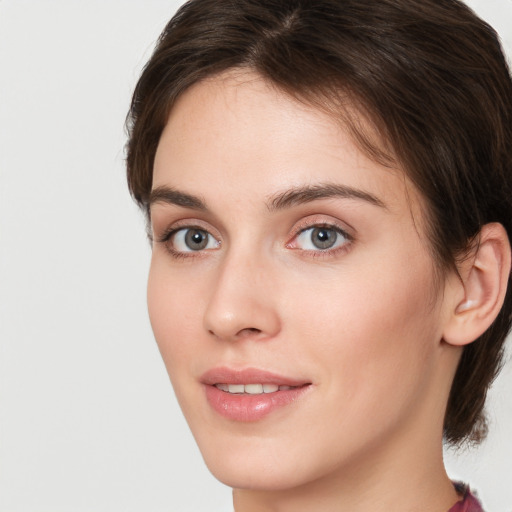 Joyful white young-adult female with medium  brown hair and green eyes