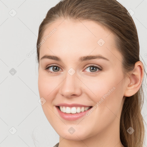 Joyful white young-adult female with long  brown hair and grey eyes