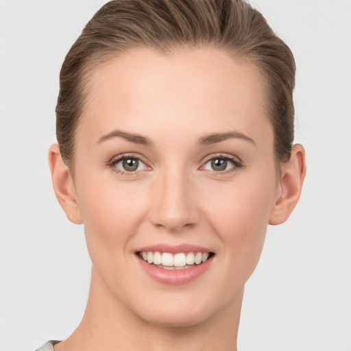 Joyful white young-adult female with short  brown hair and grey eyes