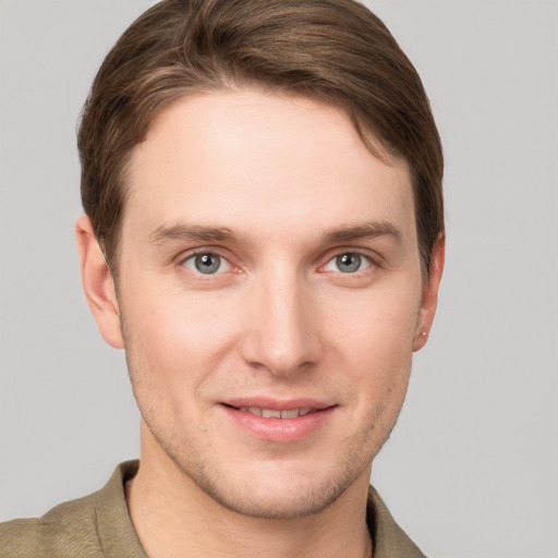 Joyful white young-adult male with short  brown hair and grey eyes