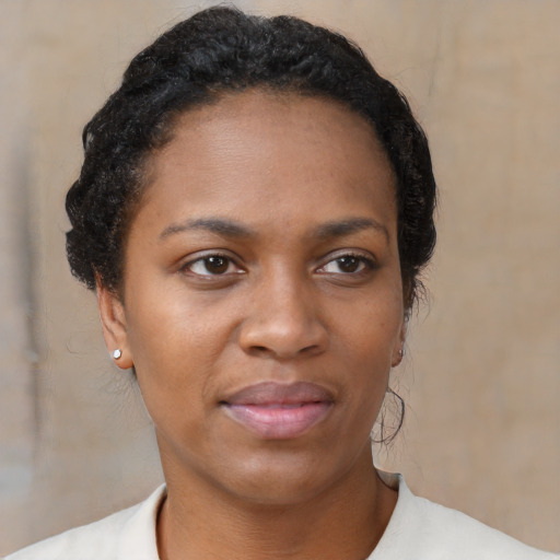 Joyful black young-adult female with short  brown hair and brown eyes