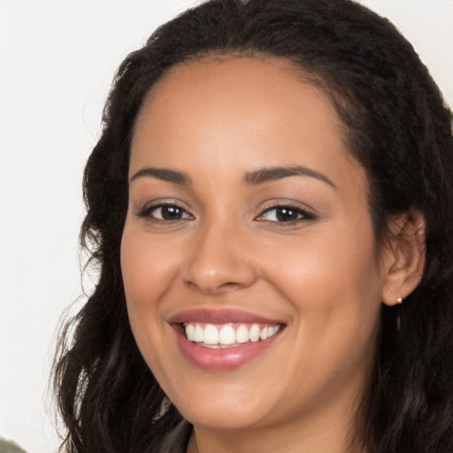 Joyful latino young-adult female with long  brown hair and brown eyes